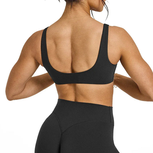 Female model wearing black sports bra and high-waisted black leggings from back, fitness activewear